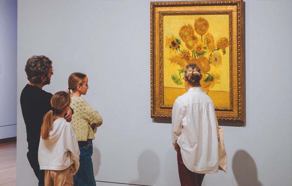 Interior of the Van Gogh Museum with visitors viewing Van Gogh’s famous works like Sunflowers